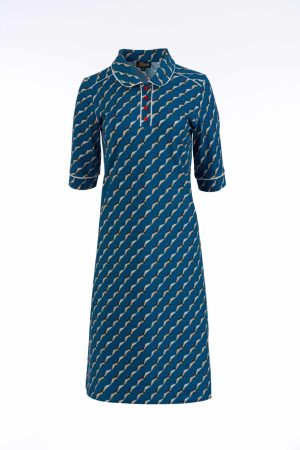 LaLamour Kjole Cato Polo retro Swallow Migration Denne kjole har et elegant og klassisk design med et smukt mønster af skrå linjer og små detaljer. Den er i en dyb blå farve med kontrastmønstre, hvilket giver et stilfuldt og tidløst udtryk. Kjolen har en flatterende A-facon, der falder løst omkring kroppen, hvilket gør den både komfortabel og feminin. De halvlange ærmer og den fine krave med knapdetaljer tilfører et vintagepræg, mens stoffet ser let og åndbart ud, perfekt til både hverdag og mere formelle lejligheder. Den kan styles med et par enkle sko eller støvler og eventuelt et bælte for at fremhæve taljen. En flot kjole til dem, der elsker en kombination af retro og moderne stil! LaLamour Kjole Cato Polo retro Swallow Migration kan du bruge nu med et par ensfarvet strømpebukser fra Pamala Mann dem finder du også her på shoppen i et væld af farver. Perfekt til både afslappede og formelle lejligheder. Bestil nu og bær mode med en god følelse!
