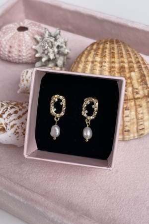 Therslund Smykker Augusta Ørestikker Tilføj et strejf af elegance til dit look med vores smukke Augusta øreringe. Smukke og enkle ørestikker med ferskvandsperler og Zirkonia sten. Øreringene tilfører en kontrast til det varme guld og giver øreringene et tidløst, feminint præg. Disse øreringe er alsidige og passer perfekt til: Festlige lejligheder som bryllupper eller middage Et sofistikeret hverdagslook En enkel kjole eller en klassisk skjorte Designet forener klassisk og let asymmetrisk udtryk, hvilket gør dem til en stilfuld detalje, der kan løfte ethvert outfit. De er den ideelle gaveidé eller et elegant tilbehør til både hverdag og særlige anledninger. Alle vores smykker er nikkel- og blyfri og overholder dansk lovgivning. Smykkerne fremstilles i messing eller rustfrit stål og kombineres ofte med glasperler eller halvædelsten for at skabe unikke og holdbare designs.