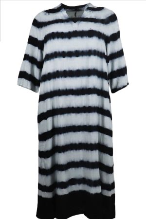 Ofelia Kjole Sati Black Combi Den her en fin / lang og afslappet og stilfuld hverdagsfavorit med et klassisk twist. Den er lavet i 100 % Viskose med et sort og hvidt bastik print V hals men lille kina krave. Pasformen er løs og behagelig ,så den falder flot og giver god bevægelsesfrihed. De korte ærmer gør den perfekt til varmere dage, eller du kan style den med en langærmet bluse under, når det er køligere. Sådan kan du style den: Som kjole med bare ben Med sneakers for et casual look Med sandaler for et sommerligt outfit