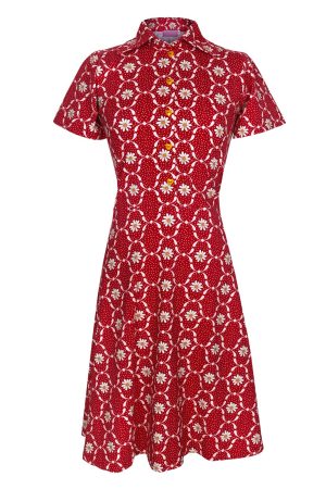 Margot Kjole Flossy Flaminco Kjolen har et markant og legende retro-look med et klart 60’er/70’er-inspireret mønster. Kraftig rød bund med hvide prikker og blomster i hvid/gul. Grafiske cirkler kombineret med margueritlignende blomster giver et vintage og næsten psykedelisk udtryk. Figursyet overdel med markeret talje og et let udsvinget A-formet skørt, som giver en feminin silhuet. Korte ærmer gør den velegnet til forår og sommer. Klassisk skjortekrave giver kjolen et lidt struktureret og elegant touch. Gule knapper foran matcher blomstercentrene og tilfører en fin kontrastdetalje. Den skønne kjole balancerer mellem retro, romantisk og sommerlig — noget man kunne style både casual med sneakers eller mere elegant med sandaler/hæle.