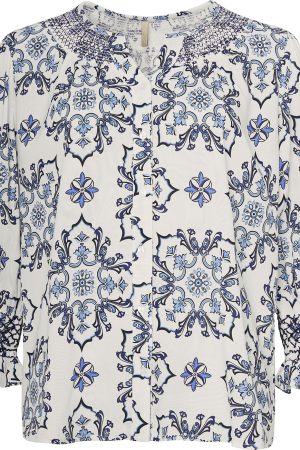 Ofelia Bluse Fie Blue Combi Ofelia Bluse Fie Blue Combi er fremstillet i 100% viskose, hvilket gør den både let og behagelig at have på hele dagen. Blusen er elegant med elastik detalje og elastiske manchetter, der tilføjer et sofistikeret præg til designet. Med sin løse pasform er den perfekt til både hverdagsbrug og festlige lejligheder, hvor komfort og stil går hånd i hånd. Den klassiske blå farve gør det nemt at style blusen med både lyse og mørke underdele, hvilket giver et alsidigt og tidløst look. Ofelia er et brand, der forener funktionalitet og stil. Med deres alsidige designs kan du nemt transformere dit hverdagsoutfit til et festligt look. Tilføj blot nogle smukke smykker eller skift skoene ud, og du er klar til alt fra kontoret til cocktailbaren.