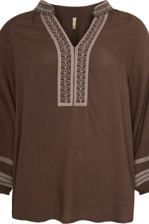 Ofelia Bluse Dolly Brown Ofelia Bluse Dolly Brown er fremstillet i 100% viskose, hvilket gør den både let og behagelig at have på hele dagen. Blusen er elegant medV-udskæring med en kort stolpe og en lav, stående krave, der tilføjer et sofistikeret præg til designet. Med sin løse pasform er den perfekt til både hverdagsbrug og festlige lejligheder, hvor komfort og stil går hånd i hånd. Den klassiske brune farve gør det nemt at style blusen med både lyse og mørke underdele, hvilket giver et alsidigt og tidløst look. Ofelia er et brand, der forener funktionalitet og stil. Med deres alsidige designs kan du nemt transformere dit hverdagsoutfit til et festligt look. Tilføj blot nogle smukke smykker eller skift skoene ud, og du er klar til alt fra kontoret til cocktailbaren.