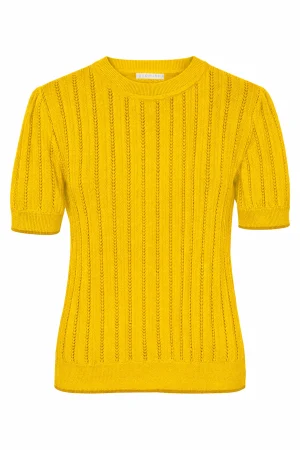 Grobund T-shirts Almine Golden Yellow Almine strik tee fra GROBUND er en elegant og komfortabel t-shirt fremstillet i en eksklusiv strikkvalitet af økologisk bomuld. Det fine pointelle-strik skaber et delikat hulmønster og tilfører blusen en unik struktur og et raffineret udtryk. Den smukke soft rose farve giver strikteen et frisk og sofistikeret look, der kan løfte ethvert outfit. Som en ekstra detalje har vi tilføjet en kontrastfarve ved ærmekanterne og forneden, hvilket giver designet et moderne twist. Strikteen har en klassisk pasform, og de korte ærmer er designet med en diskret puff-effekt, der tilføjer et feminint touch til det samlede udtryk. Som altid er Almine tee 100% GOTS-certificeret, så du kan bære den med god samvittighed.