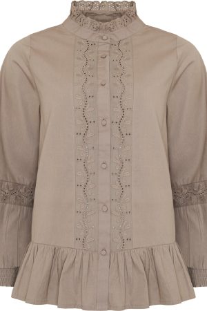 Ofelia Skjorte Jera Latte Ensfarvet lys taupe/beige nuance, som giver et roligt og tidløst look. Skjorten har en høj flæsekrave med broderie anglaise, der tilfører et raffineret og vintage-inspireret præg. Den lukkes med stofbetrukne knapper langs fronten, hvilket understreger det elegante design. På forstykket er der lodrette broderede paneler med hulbroderi, som skaber struktur og et eksklusivt udtryk. De lange ærmer har en let ballonform med broderede detaljer over albuen og smock-elastik ved manchetterne, som giver volumen og en behagelig pasform. Nederst afsluttes skjorten med en påsyet flæsekant, der tilfører let vidde og en feminin silhuet. Skjorten velegnet til både hverdagsbrug og mere elegante anledninger. Skjorten kan styles med mørke jeans for et afslappet, sofistikeret look eller med en nederdel eller pæne bukser for et mere klassisk og elegant outfit. De neutrale farver gør den nem at kombinere med både lyse og mørke nuancer.